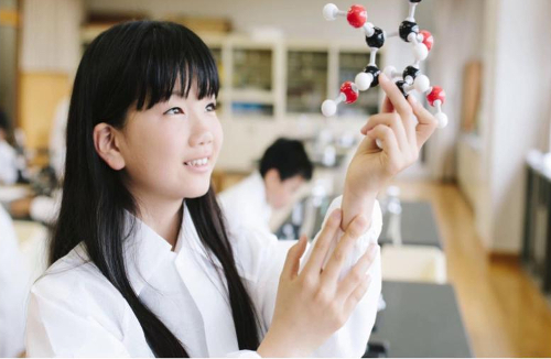 girl admiring ball and stick chemsitry model