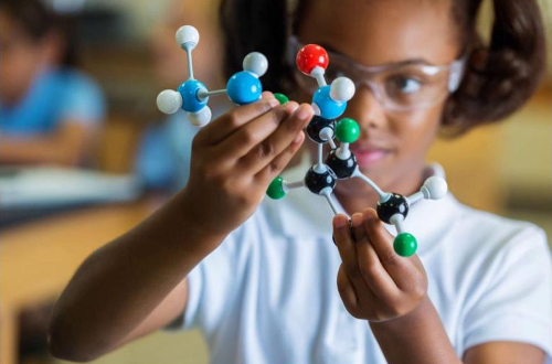 girl building ball and stick chemistry model